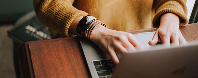 A person types at a laptop