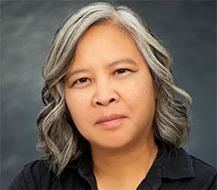 Putsata has long, wavy, gray hair.