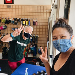 Colleagues that are wearing masks holding up peace signs