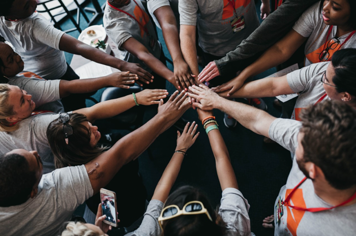 Image of several different hands all in the middle together overlapping Image of several different hands all in the middle together overlapping